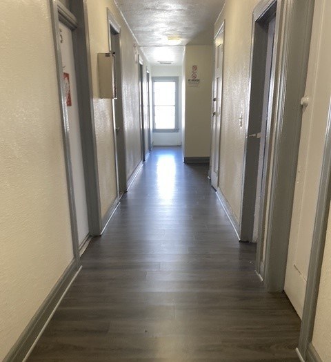 A long hallway with doors on both sides and a light at the end.
